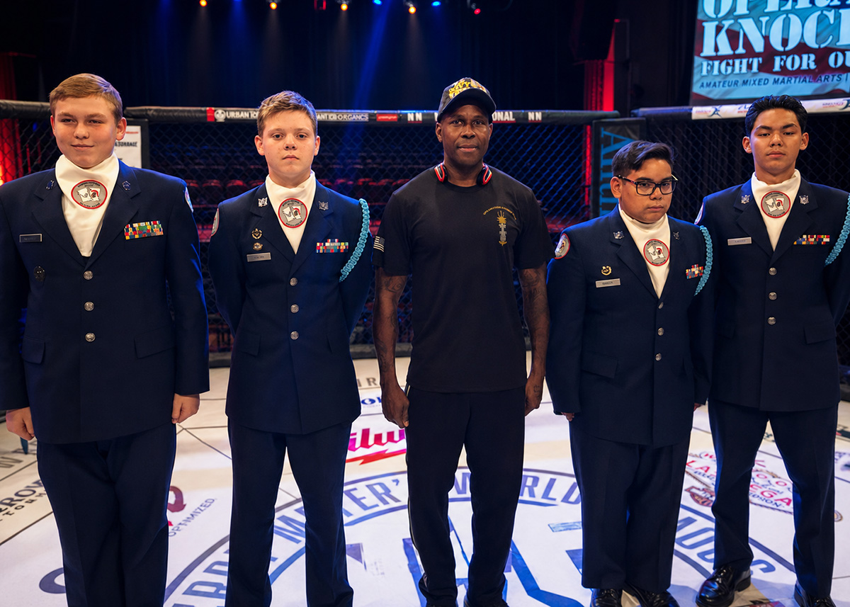 Wesley Berry standing with young cadets in uniform, raising the next generation of disciplined leaders